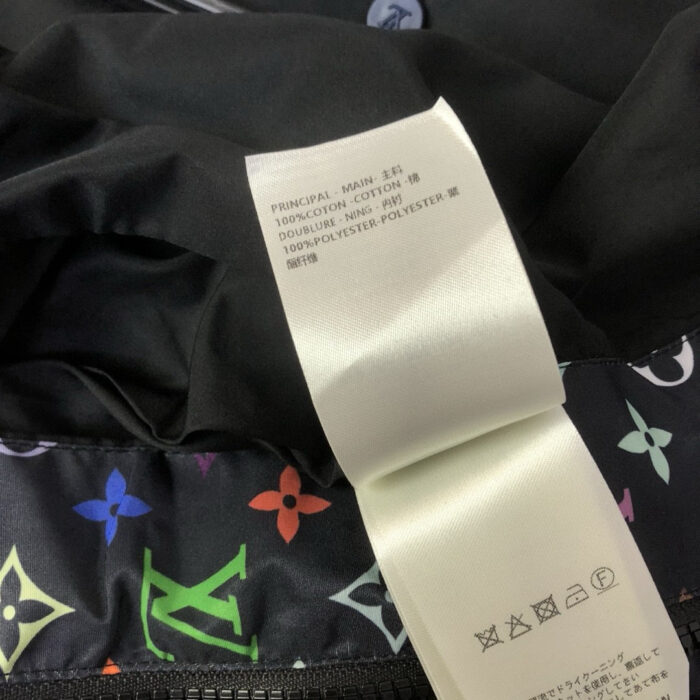 Etichetta di lusso con motivi floreali colorati su vestito elegante nero.