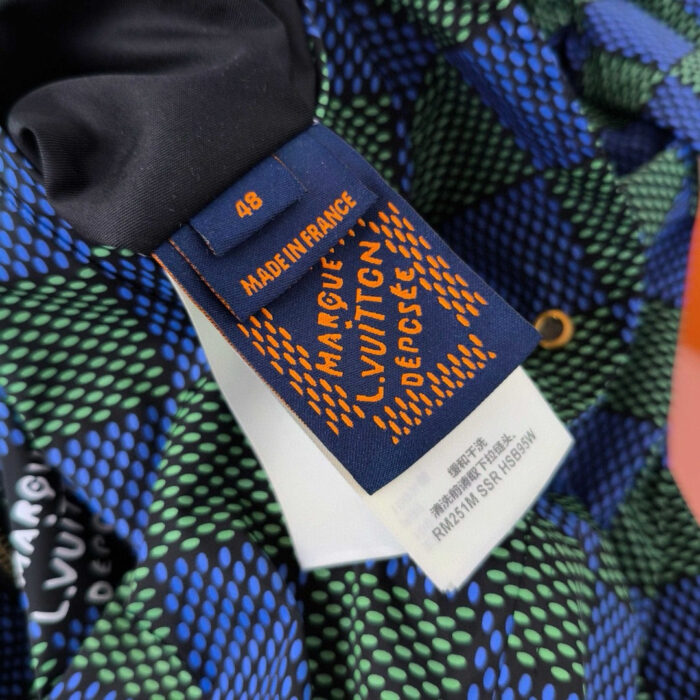Etichetta Louis Vuitton su tessuto geometrico colorato, simbolo di lusso e alta moda.