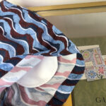Berretto di marca Gucci con design a onde colorate e dettagli eleganti.