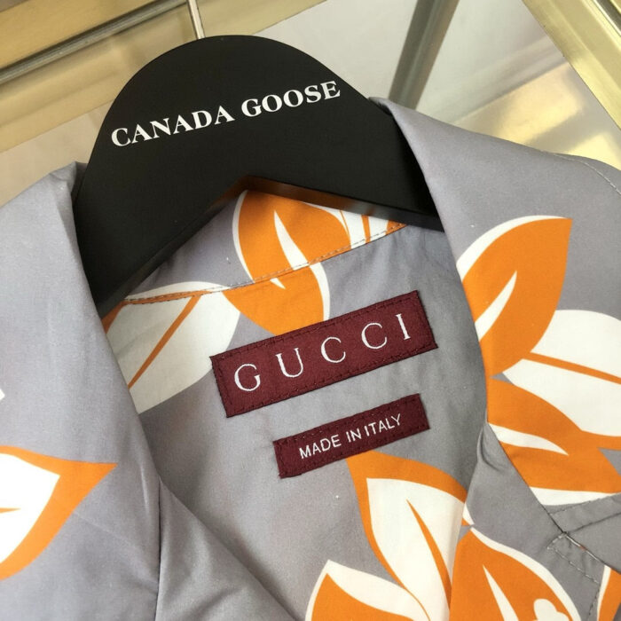 Camicia floreale con etichette Gucci e Canada Goose, stile estivo e lusso.