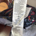 Etichetta di cura stoffa in poliestere con motivo floreale, istruzioni multilingue, styles e dettagli.