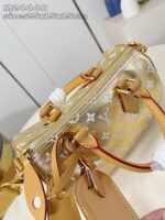 Borsetta elegante in oro metallico con logo, manici in pelle e chiusura a zip versatile.