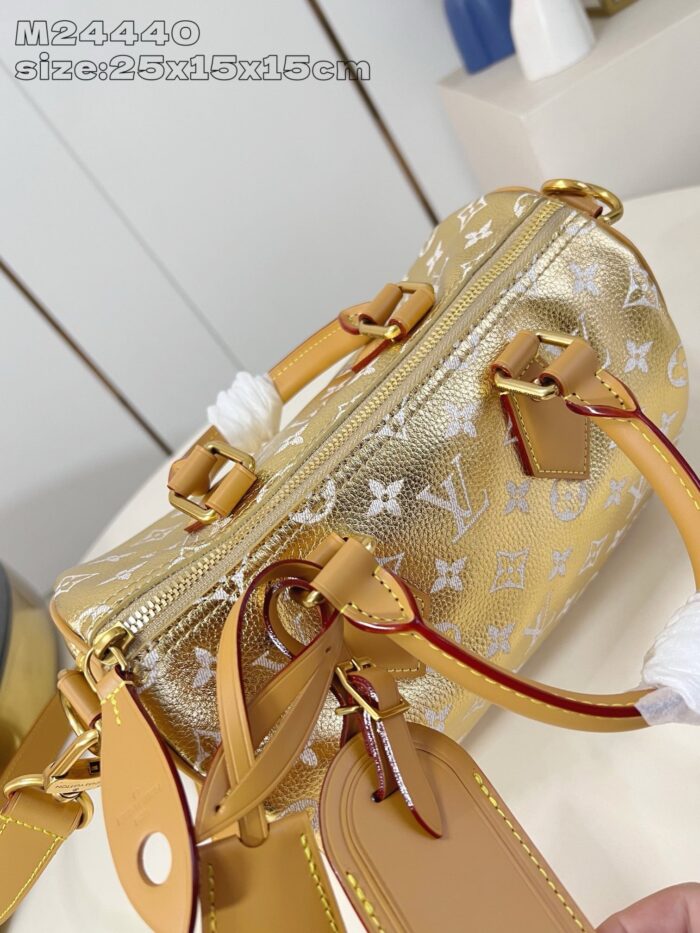 Borsetta elegante in oro metallico con logo, manici in pelle e chiusura a zip versatile.