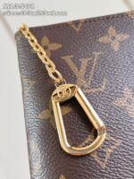 Gancio in oro su tessuto di lusso, con motivo iconico e dettagli eleganti.