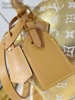 Borsa di lusso dorata con dettagli in pelle caramello e motivo monogramma elegante.