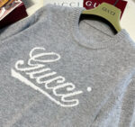 Maglione Gucci grigio di lusso con logo bianco in stile elegante e moderno.