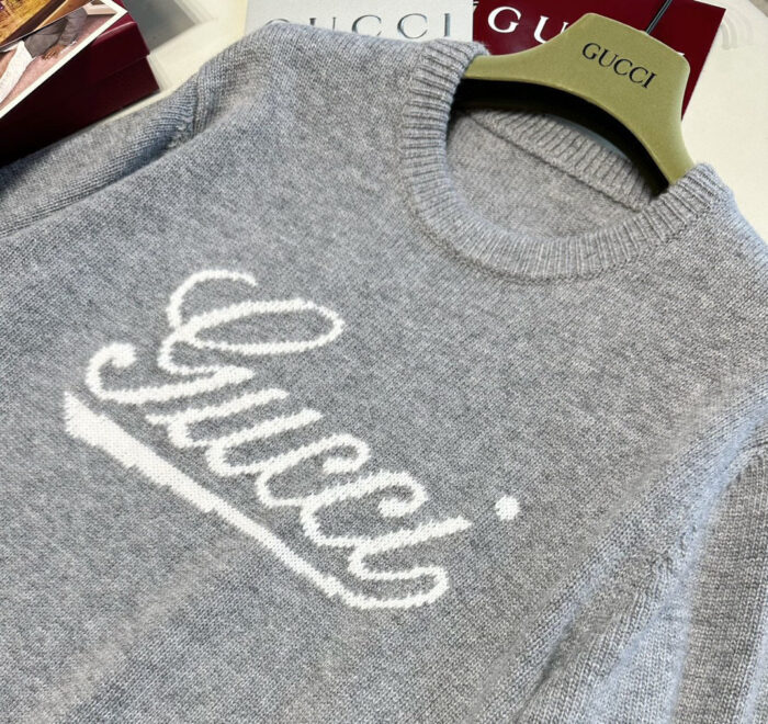 Maglione Gucci grigio di lusso con logo bianco in stile elegante e moderno.