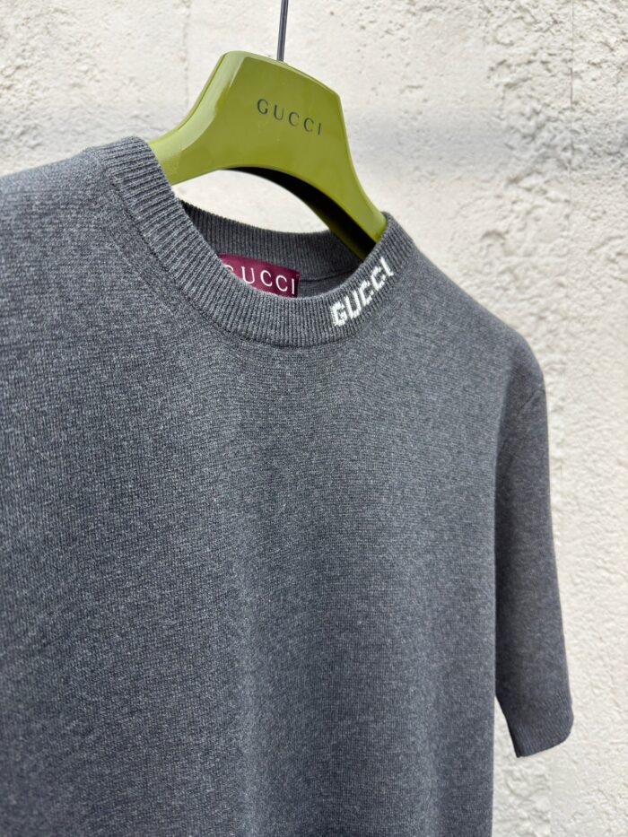 Maglione Gucci grigio con logo, gancio design verde, stile minimalista e lusso elegante.