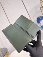 Portafoglio in pelle verde di lusso con scomparti eleganti e dettagli raffinati.