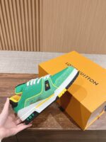Sneaker di lusso verde con dettagli contrasto, suola robusta e packaging esclusivo arancione.