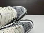Sneakers di lusso grigie moderne, sporty, con dettagli raffinati, lacci crema e suola robusta.