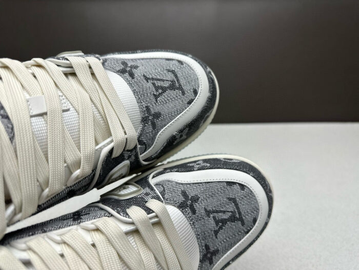 Sneakers di lusso grigie moderne, sporty, con dettagli raffinati, lacci crema e suola robusta.