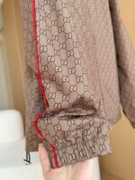 Giacca Gucci beige con logo interlocked e dettaglio rosso, stile moderna e di alta qualità.