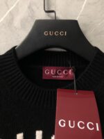 Maglione Gucci nero con collo a costina, etichetta di lusso Made in Italy.