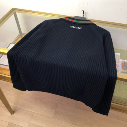 Maglione Gucci blu navy con logo elegante e dettagli a righe, stile sofisticato e chic.