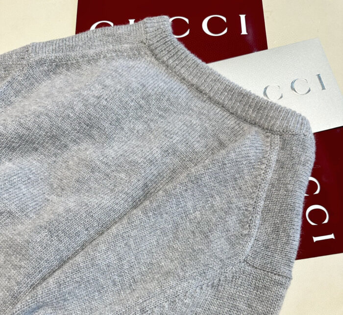 Maglione Gucci in cashmere grigio, elegante e confortevole, con dettagli di lusso e stile raffinato.