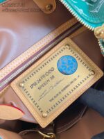 Etichetta elegante in oro su borsa di lusso con logo blu e dettagli raffinati.