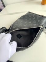 Borsa di lusso grigia con monogramma, dettagli eleganti e chiusura a zip raffinata.
