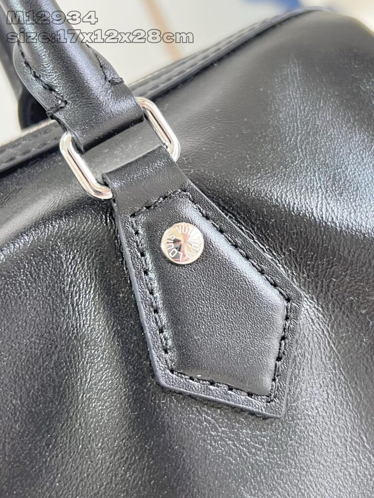 Dettaglio della tracolla in pelle nera e accessori metallici di alta qualità.