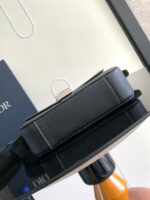 Custodia in pelle nera di lusso con cuciture bianche, elegante e moderna su superficie riflettente.
