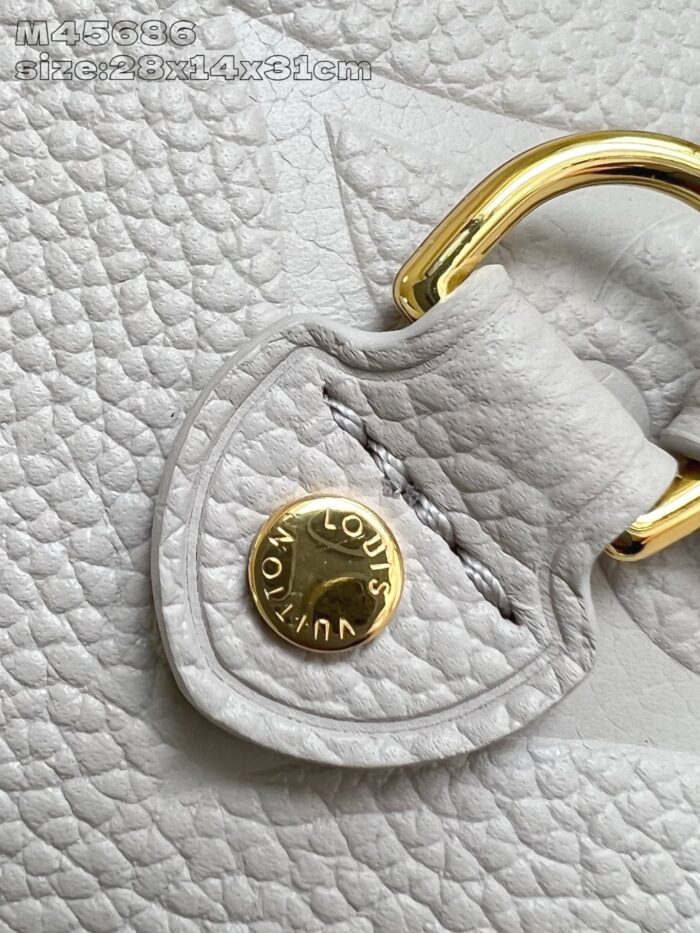 Dettaglio cuoio Louis Vuitton con bottone dorato e cuciture impeccabili.