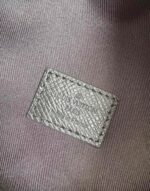 Etichetta Louis Vuitton in pelle di lusso, dettaglio rugoso e cuciture precise.