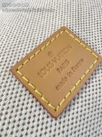 Etichetta in pelle Louis Vuitton con logo e Made in France su tessuto raffinato.