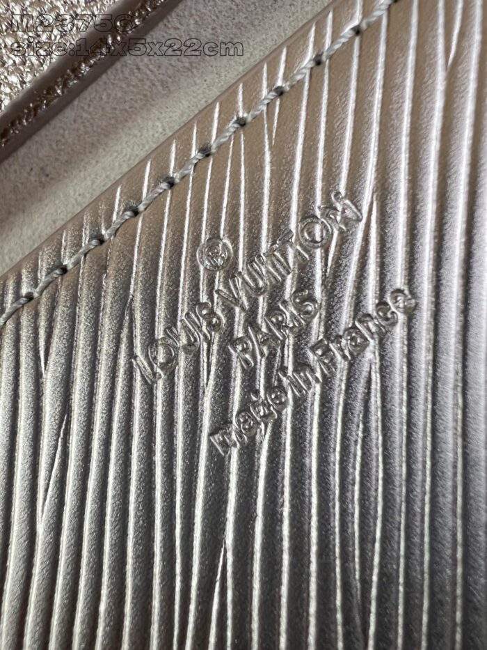 Dettaglio di pelle Louis Vuitton incisa con firma e Made in France su texture elegante.