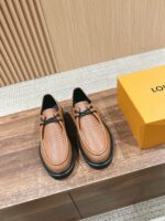 Scarpe in pelle cognac di lusso con scatola arancione, stile elegante e artigianale.