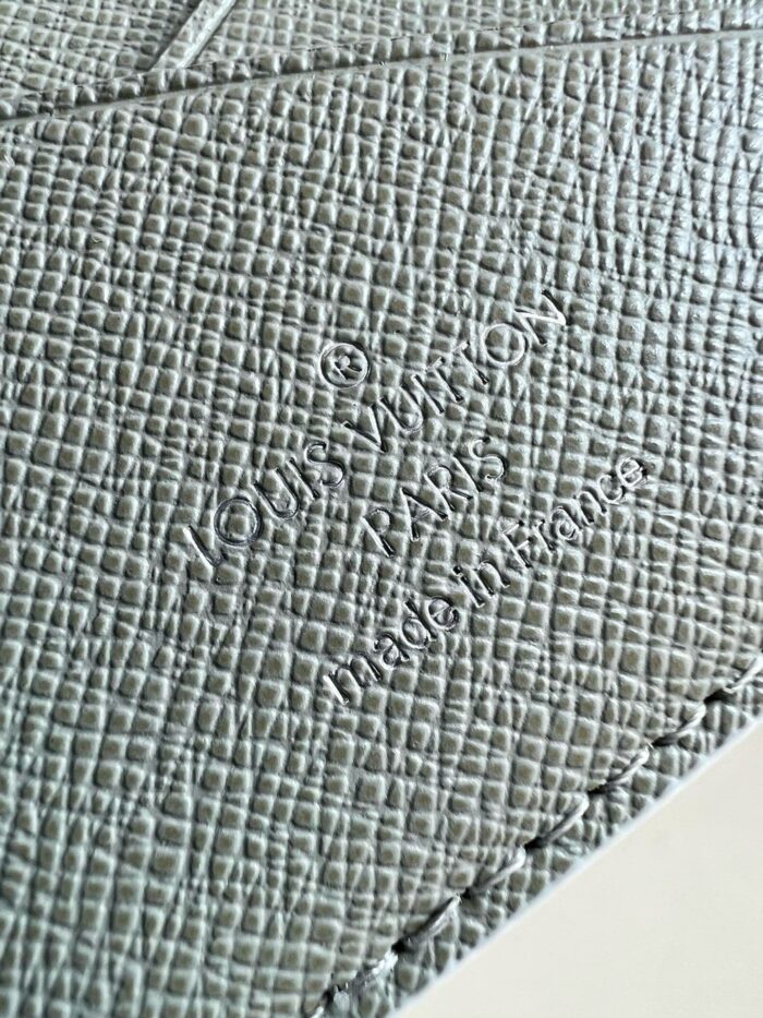 Texture elegante in grigio con logo Louis Vuitton inciso, dettagli raffinati e cuciture di alta qualità.