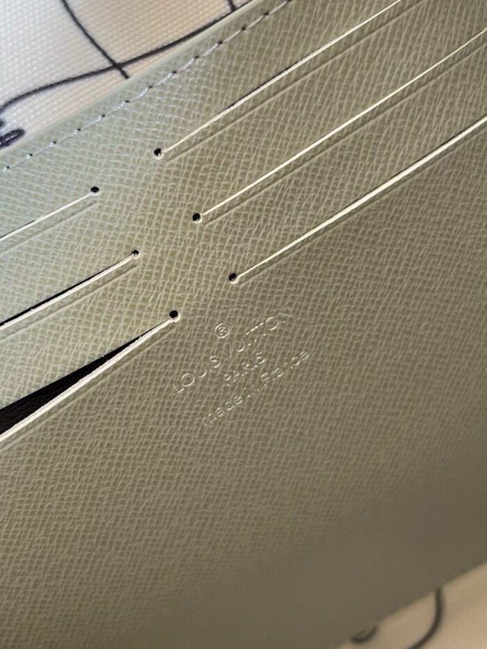 Texture di pelle sintetica verde con linee perforate e logo discreto, elegante e di alta qualità.