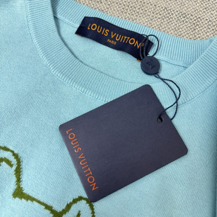 Maglione Louis Vuitton blu pastello con ricamo verde e etichetta di lusso.