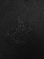 Logo Louis Vuitton tono su tono su tessuto nero, elegante e discreto.