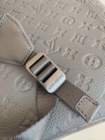 Borsa di lusso in pelle grigia con dettaglio strap e fibbia in metallo satinato.
