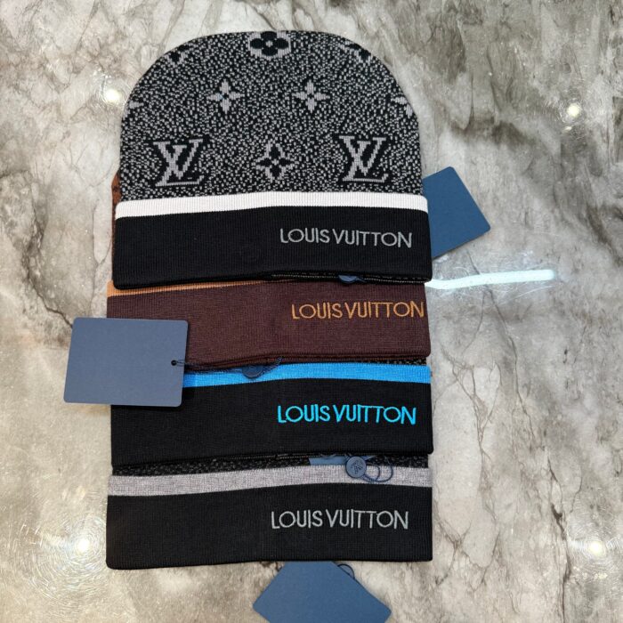 Collezione di berretti e fasce Louis Vuitton di lusso su superficie in marmo elegante.