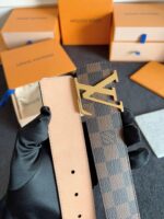 Cintura Louis Vuitton in pelle e canvas con fibbia dorata, stile elegante e logo iconico.
