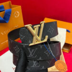 Cintura Louis Vuitton con fibbia oro e motivo monogramma su sfondo rosso elegante.