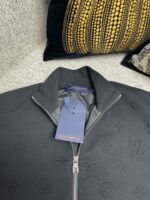 Giacca nera Louis Vuitton embossonata, elegante e moderna, dettaglio di alta moda e stile sofisticato.