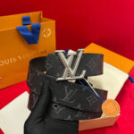 Cintura Louis Vuitton nera con logo in argento, confezione elegante con fiocco blu.