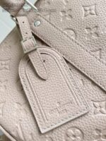 Borsa di lusso in pelle beige con dettaglio elegante e tag coordinato.