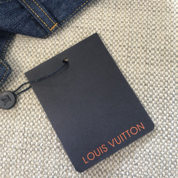 Etichetta Louis Vuitton su jeans di denim di lusso con logo arancione.