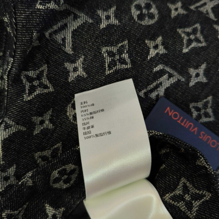 Tessuto monogramma di lusso con etichetta di cura e dettagli raffinati.