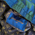 Dettaglio di una giacca Louis Vuitton con monogramma, pattern colorati e dettagli di alta qualità.