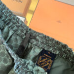Pantaloncini Louis Vuitton verdi con monogramma, elastici e etichetta elegante, confezione di lusso inclusa.