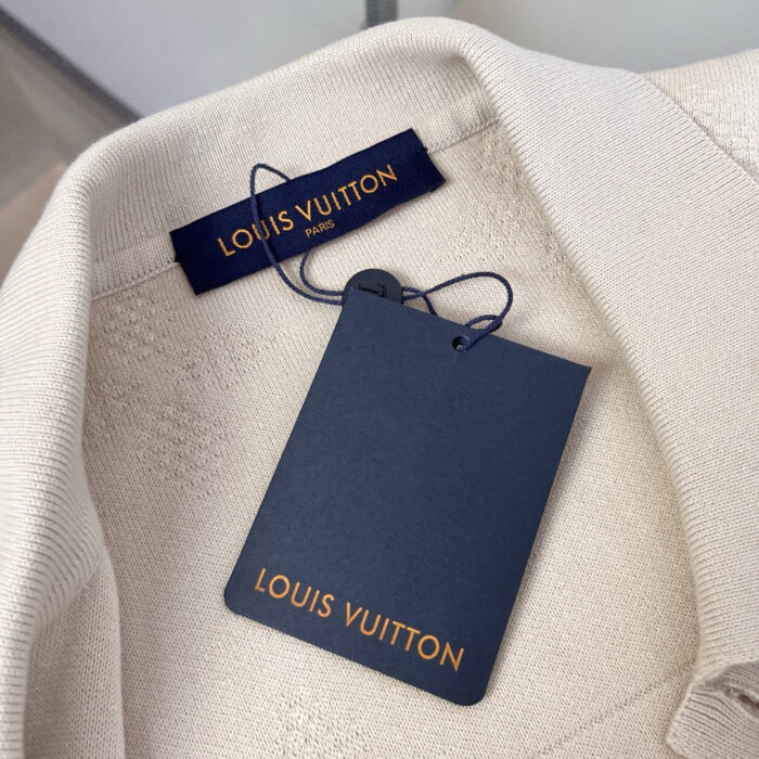 Etichetta e tag Louis Vuitton di lusso su abbigliamento elegante beige.