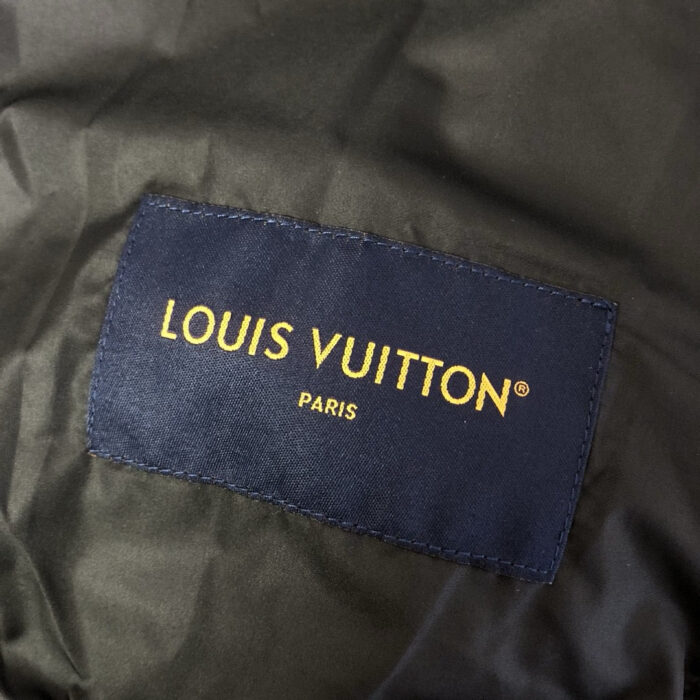 Etichetta Louis Vuitton su tessuto verde scuro, dettagli elegante e qualità di lusso.