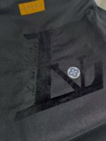 Logo Louis Vuitton con dettagli colorati su superficie in pelle di alta qualità.
