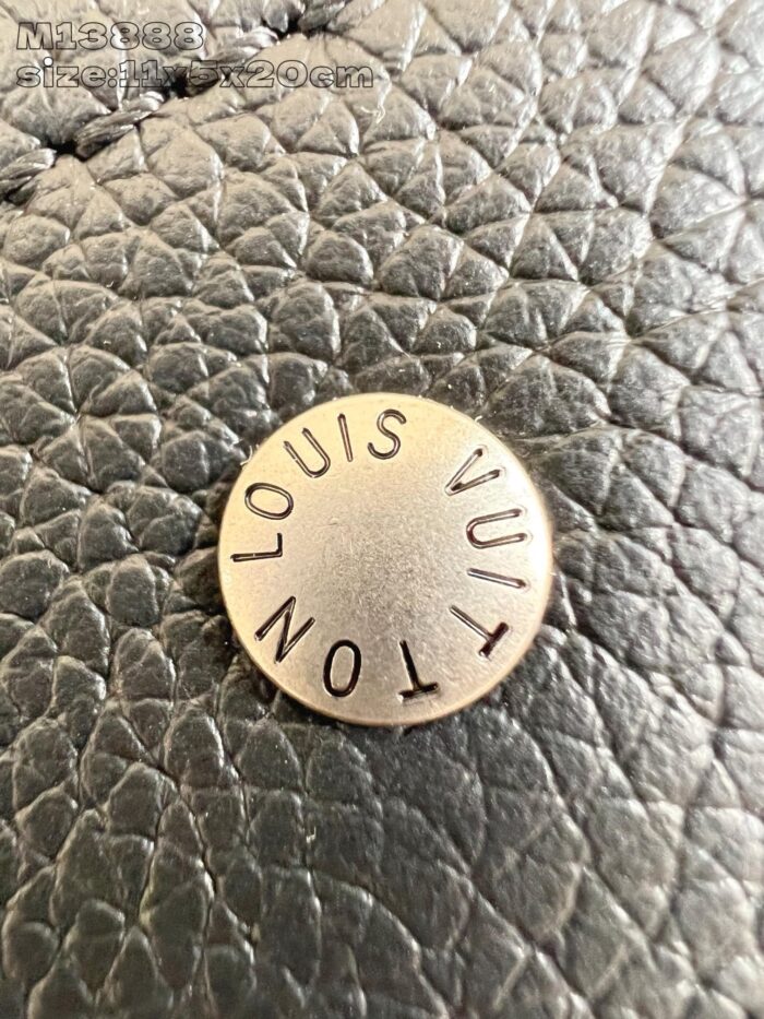 Emblema in metallo Louis Vuitton su pelle di alta qualità per accessori di lusso.