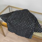 Tessuto Louis Vuitton Monogram su tavolo in vetro, elegante e di lusso.