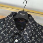 Camicia Louis Vuitton monogramma, appesa su gancio Prada in boutique di lusso.